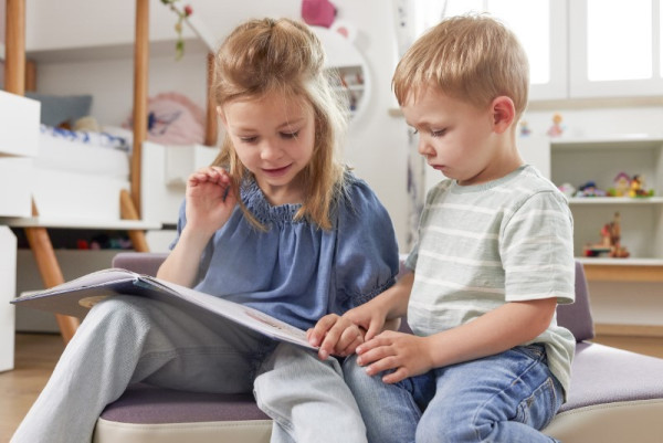 Hüpfpolster mit Kindern, lesend links