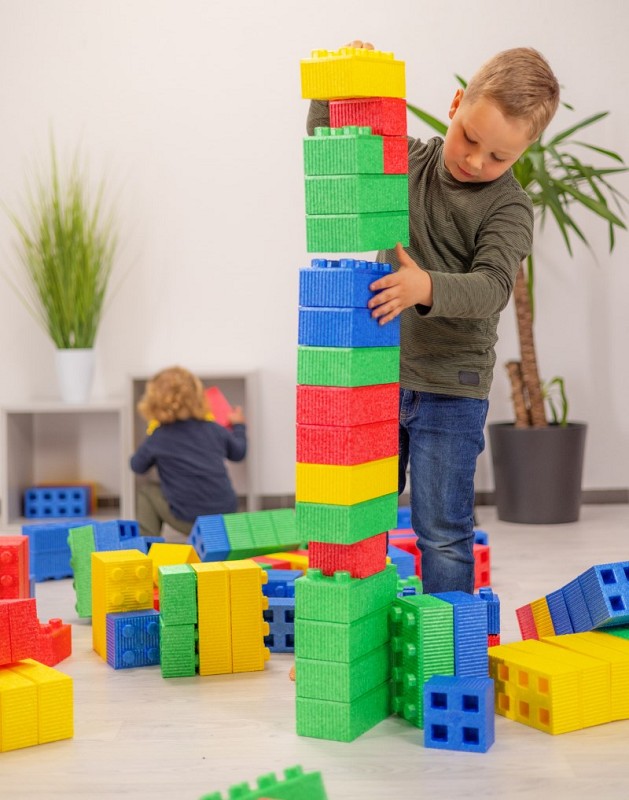 Junge baut Turm mit MODO Softbausteinen hinten